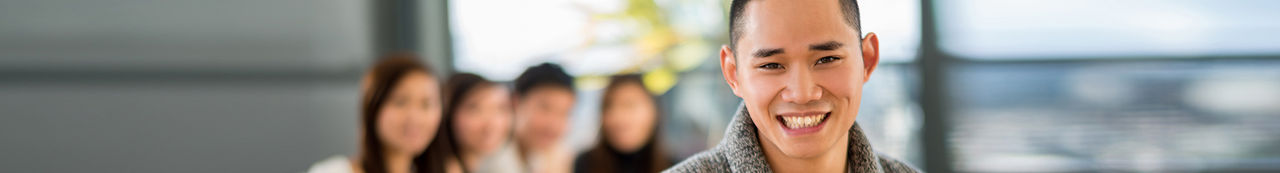 Happy male student with a group of friends