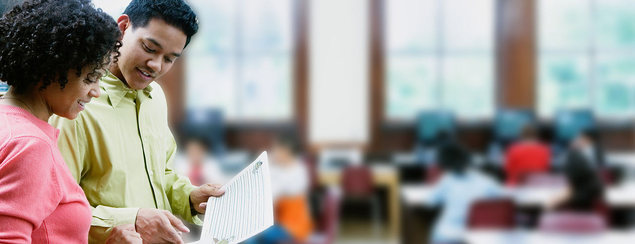 man and woman looking at a paper