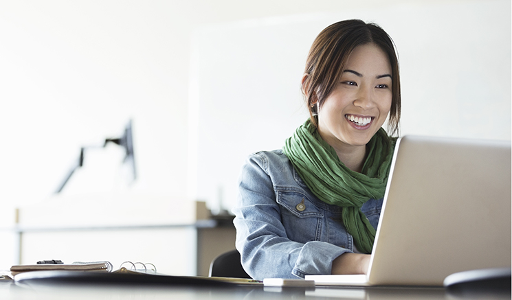 A woman smiling and seeing laptop