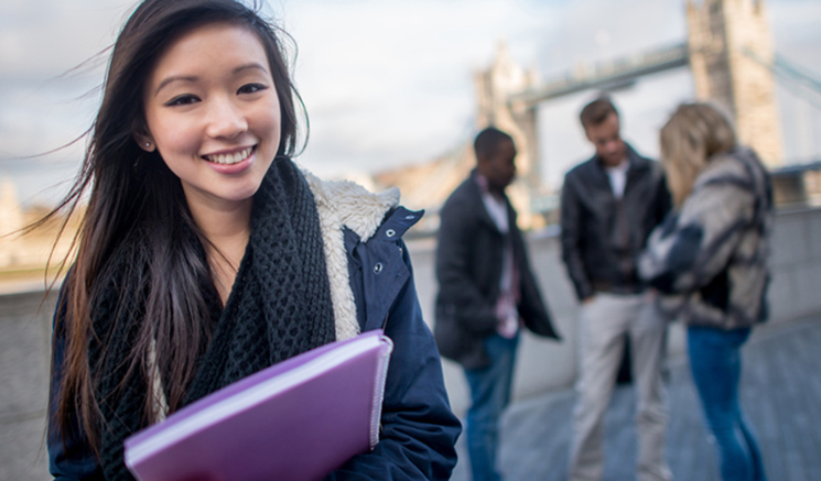 Happy Asian woman studying English in London